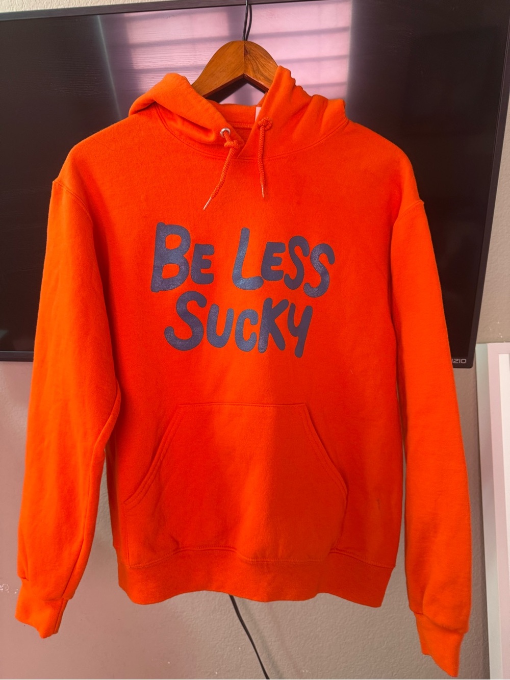 Orange Hooded Sweatshirt with 'Be Less Sucky' Graphic. Unisex size Small